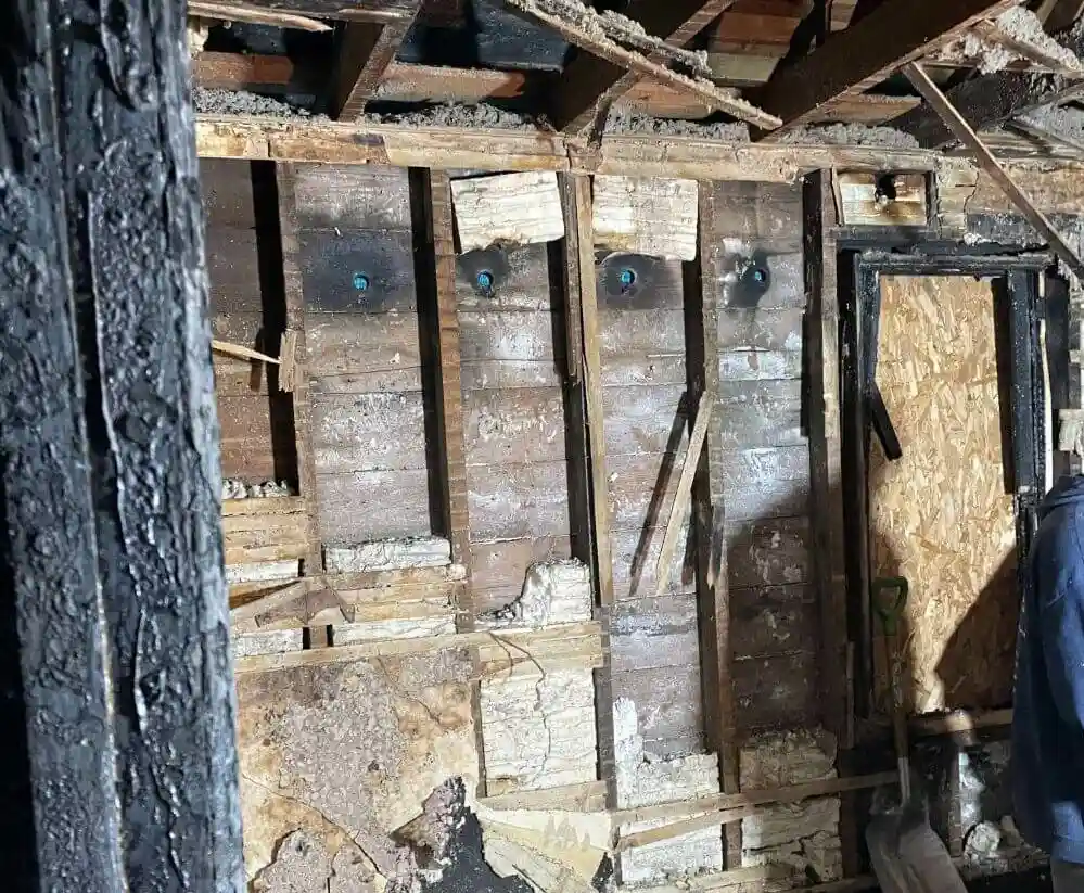 Wooden wall with fire damage and smoke damage before restoration.